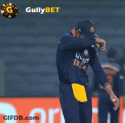 Man With Head Down In Front Of Gullybet Ad GIF