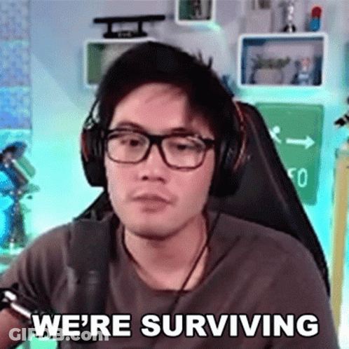 Man With Headphones And Glasses Saying We're Surviving GIF