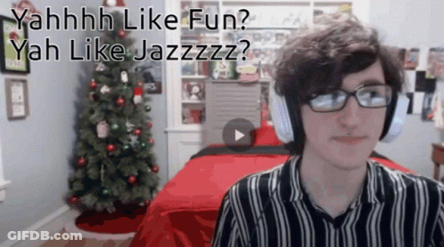 Man With Headphones And Glasses Sitting By Christmas Tree With Play Button GIF