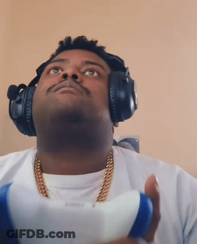 Man With Headphones And Gold Chain Holding PlayStation Controller GIF