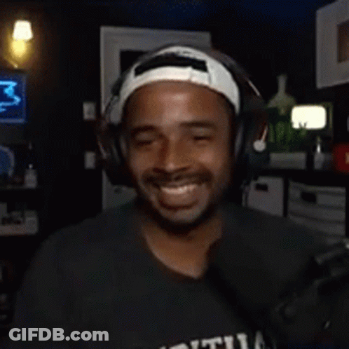 Man With Headphones And Headband Smiling In Dark Room GIF