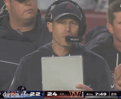 Man With Headphones And Sony Microphone In Front Of Scoreboard GIF