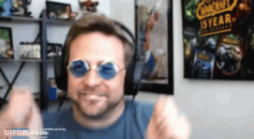 Man With Headphones And Sunglasses In Front Of Warcraft Poster GIF