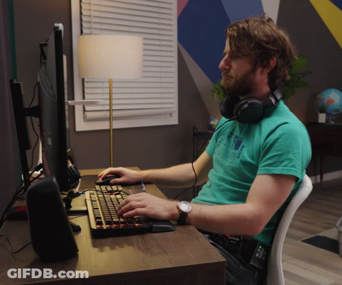 Man With Headphones At Desk With Keyboard GIF