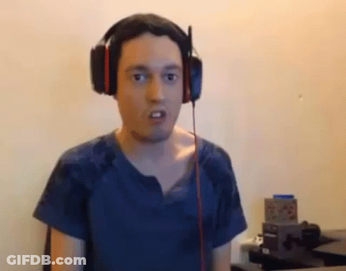 Man With Headphones Funny Face At Desk GIF