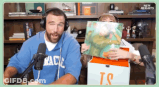 Man With Headphones Holding Book Woman With TS Box GIF