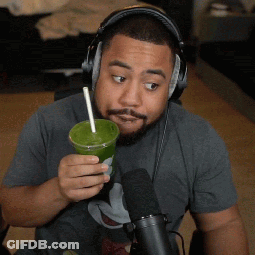 Man With Headphones Holding Green Drink GIF