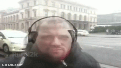 Man With Headphones In Front Of Building GIF
