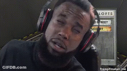 Man With Headphones In Front Of Lofts Sign GIF