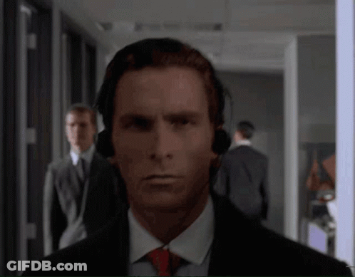 Man With Headphones Looking At Camera In Hallway GIF
