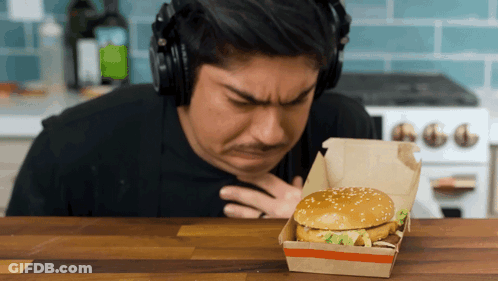 Man With Headphones Looking At Hamburger In Box GIF