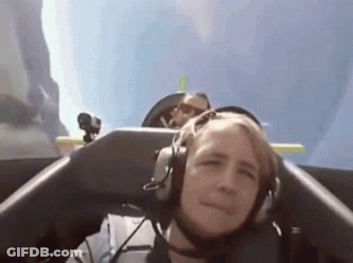 Man With Headphones On Plane, Another Man Behind GIF
