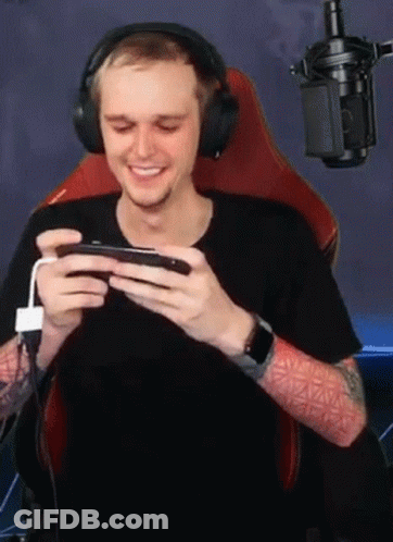 Man With Headphones Playing Game On Phone GIF