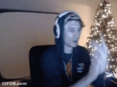 Man With Headphones Sitting By Christmas Tree GIF