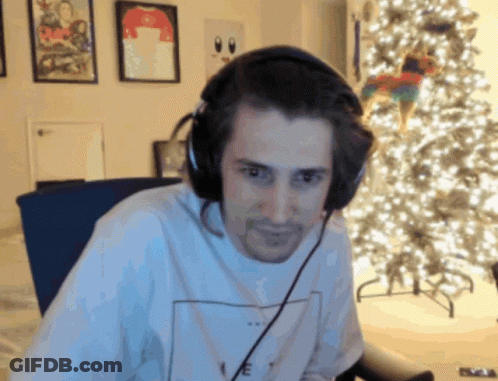 Man With Headphones Sitting By Christmas Tree GIF