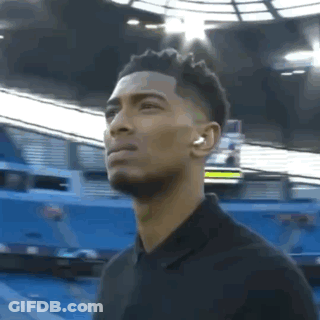 Man With Headphones Standing In Front Of Stadium GIF