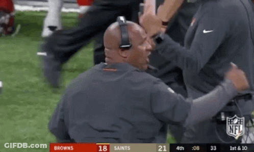 Man With Headphones Talking To Another On Football Field GIF