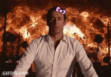 Man With Hello Kitty Bow Standing In Front Of Fire Explosion GIF
