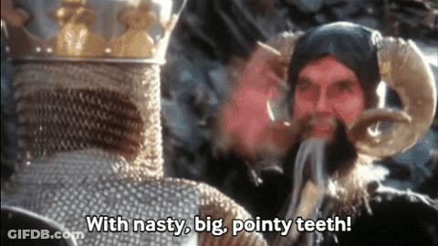 Man With Horns Talking To Bearded Man With Nasty Big Pointy Teeth GIF