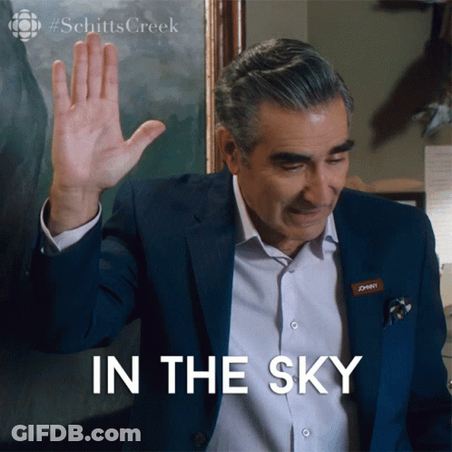 Man With Johnny Nametag Waving Hand In Front Of In The Sky Sign GIF
