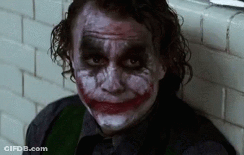 Man With Joker Makeup Sitting Next To Wall GIF