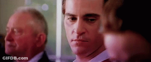 Man With Knife In Mouth Standing Next To Another Man GIF