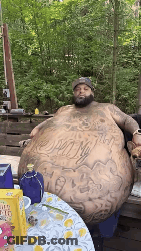 Man With Large Belly Sitting At Table With Potato Chips GIF
