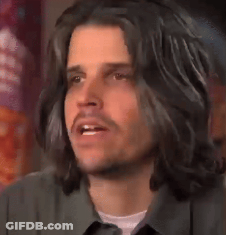 Man With Long Black Hair And Beard Looking At Camera GIF