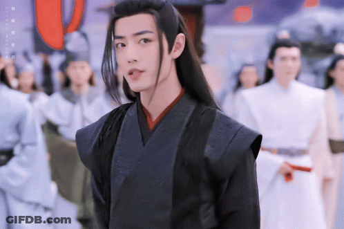 Man With Long Black Hair Standing In Crowd GIF