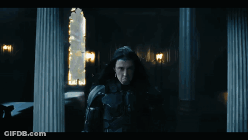 Man With Long Black Hair Standing In Dark GIF