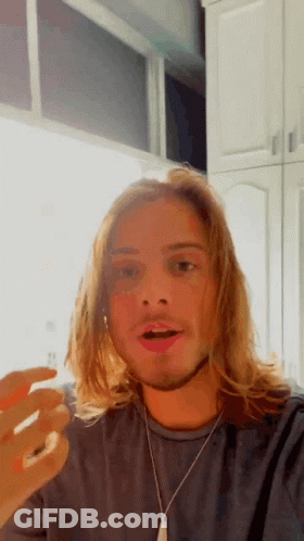 Man With Long Blonde Hair And Beard In Grey Shirt And Silver Necklace GIF