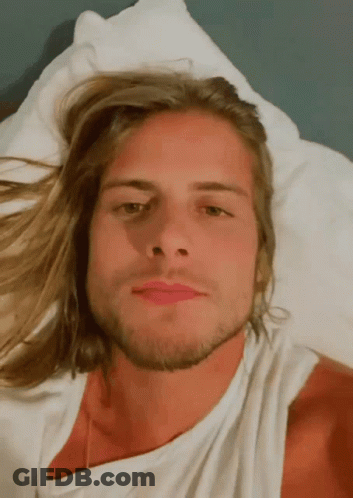 Man With Long Blonde Hair And Beard Laying On Bed GIF