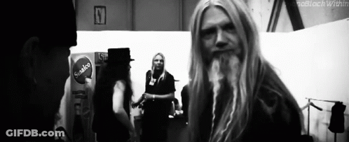 Man With Long Blonde Hair And Beard Standing In Room GIF