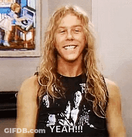 Man With Long Blonde Hair And Black Tank Top Smiling GIF