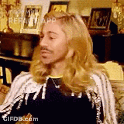 Man With Long Blonde Hair And Mustache Sitting In Chair GIF