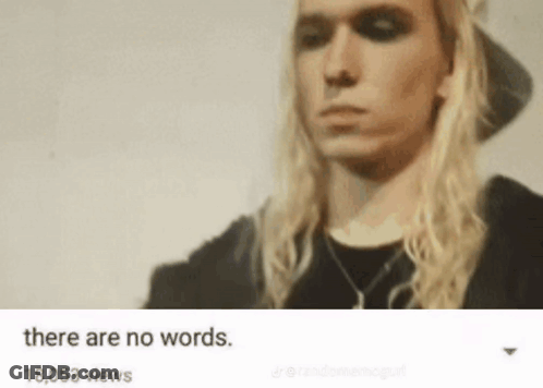 Man With Long Blonde Hair In Black Hat And Shirt GIF