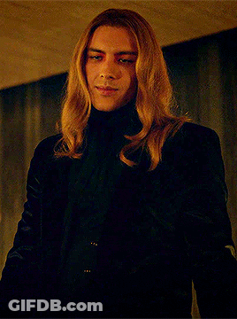 Man With Long Blonde Hair In Black Turtleneck And Jacket GIF