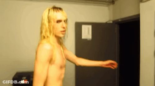 Man With Long Blonde Hair Standing In Room GIF