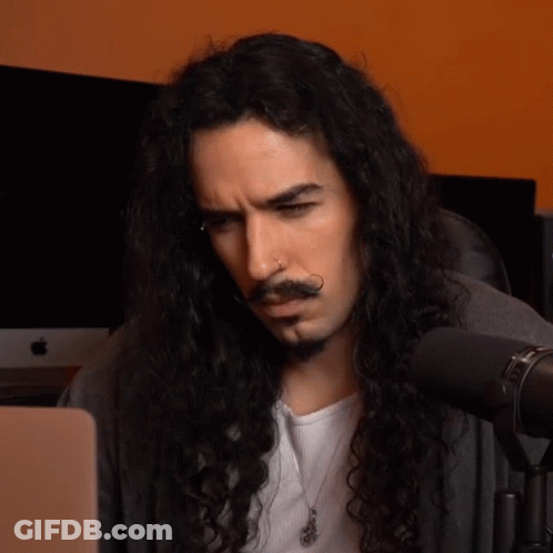 Man With Long Curly Hair And Beard Looking At Laptop GIF