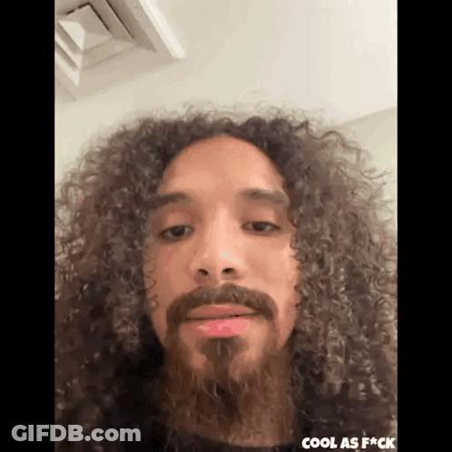 Man With Long Curly Hair And Beard Making Funny Face GIF