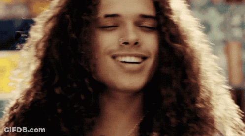 Man With Long Curly Hair And Nose Ring Smiles GIF
