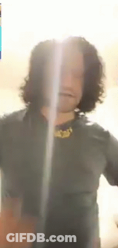 Man With Long Curly Hair Looking At Camera GIF