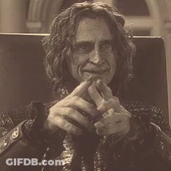Man With Long Curly Hair Sitting In Chair GIF