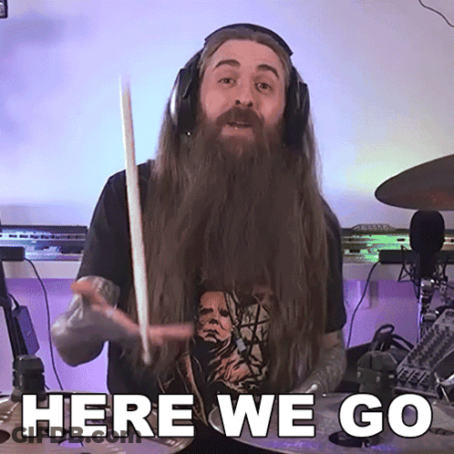Man With Long Hair And Beard Holding Drum Stick Saying Here We Go GIF