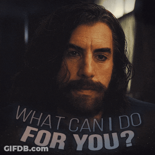 Man With Long Hair And Beard Holding Sign What Can I Do For You GIF