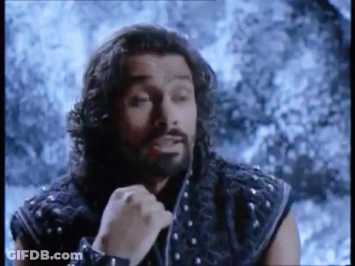 Man With Long Hair And Beard In Front Of Snowy Mountain GIF