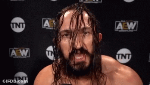 Man With Long Hair And Beard In Front Of TNT Wall GIF