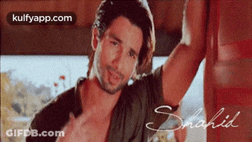 Man With Long Hair And Beard Leaning On Wall GIF