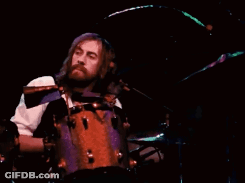 Man With Long Hair And Beard Playing Drums GIF