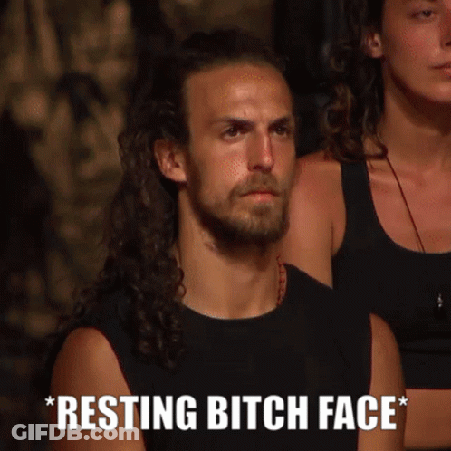 Man With Long Hair And Beard Sitting Next To Woman Saying Resting Bitch Face GIF